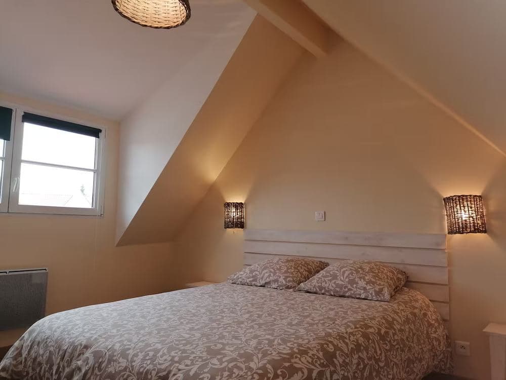 Chambre sous combles avec lit double et suspension en osier