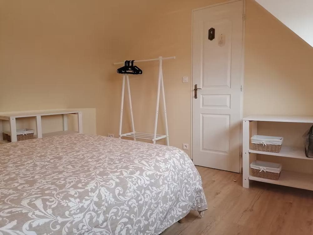 Chambre avec lit double, penderie ouverte et étagères de rangement