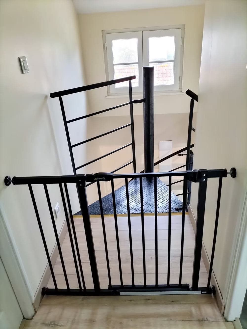 Barrière de sécurité enfant installée en haut de l'escalier hélicoïdal, à l'étage