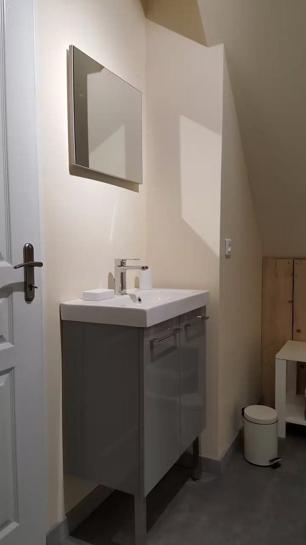 Salle de bain sous combles : vasque, meuble de rangement et miroir